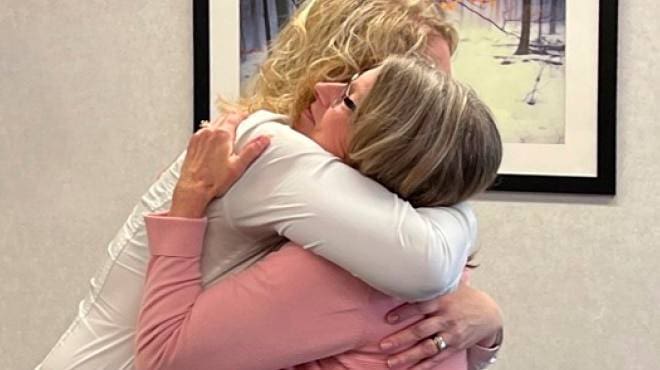 closeup of two women are hugging each other